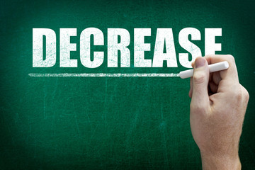 Hand writing the text DECREASE on the blackboard