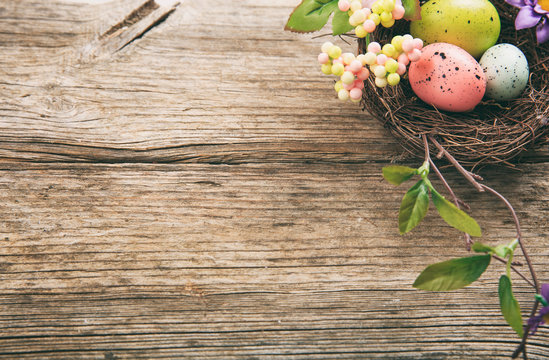 Colorful Easter eggs and copy space on wooden background
