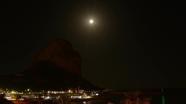 Rise of the moon over the mountain Penyal d'Ifach. Calpe. Spain. A rare event. The moon rises just above the top of the mountain Ifach. Time lapse.