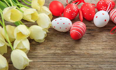 Easter eggs and tulips on wooden background and copy space