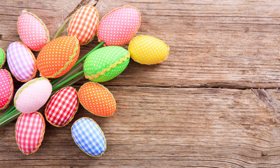 Colorful Easter eggs and copy space on wooden background