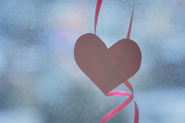 Red paper heart and ribbons on the window. Valentines day card. Selective focus.