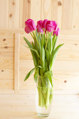 Bouquet of pink tulips on a wooden background
