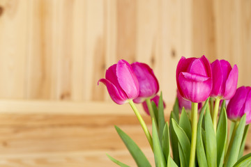 Bouquet of pink tulips on a wooden background

