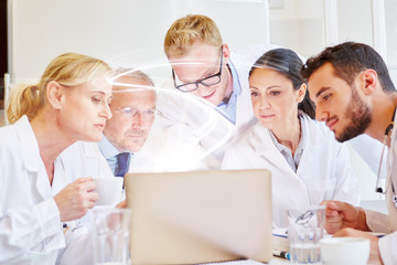 Fototapeta na wymiar Ärzte Team schaut auf Licht aus Laptop Computer