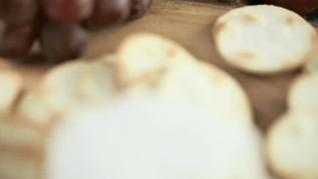 Soft flavored creamy cheese with garlic and fine herbs on a wood board with crackers