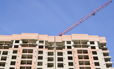 Fototapeta premium A red crane arrow over a high-rise building