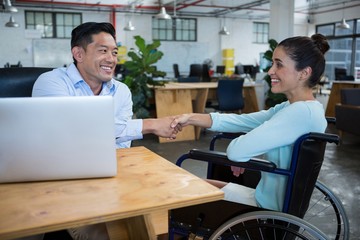 Businessman shaking hands with disabled colleague