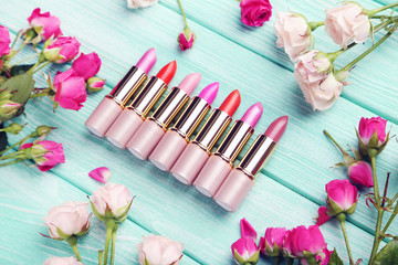 Obraz na płótnie Canvas Colorful lipsticks on mint wooden table