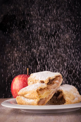 Two slices of apple strudel with spilled sugar