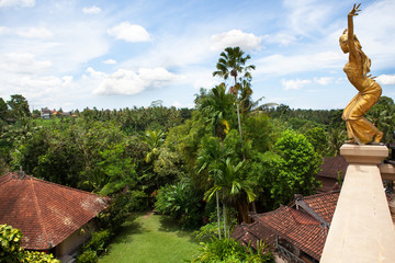 Gold statue of a woman on the roof of a house.