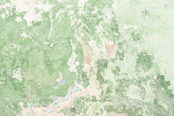 The texture of the old antique wall is green, there are fractures of the white protective layer of plaster from the effects of high humidity and atmospheric phenomena