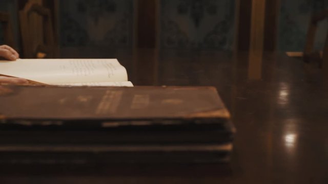 Panoramic shot an old woman leaf through book russian cursive text on table