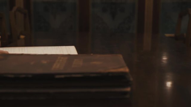 Panoramic shot an old woman thumb through book russian cursive text on table