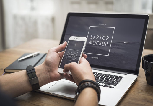 User with Smartphone and Laptop on Desk Mockup 2