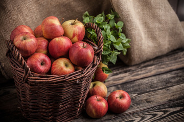 Jabłka w koszu na drewnianym tle © Olo
