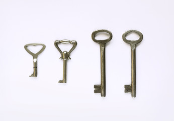 Different kinds of vintage keys on white background, top view