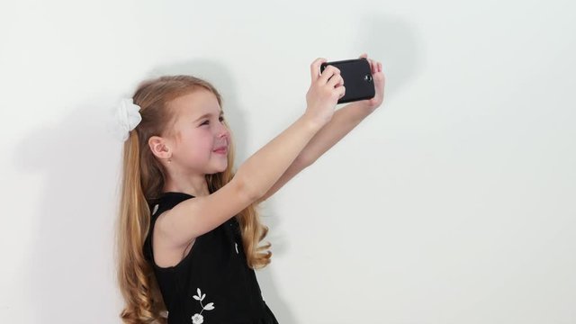 Beautiful little girl making selfie on smartphone