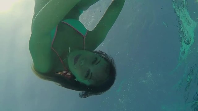 woman swimming under water 