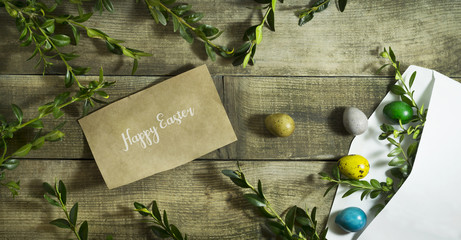 Easter colored eggs in a postal envelope on a wooden background