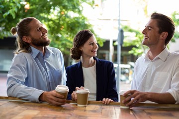 Young friends interacting with each other while having coffee