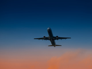 Fototapeta na wymiar Aircraft take-off from airport at sunset time. Air transportation and overnight flight theme.