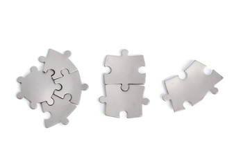 Metal puzzle pieces isolated on white