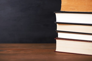  Close-up of used books stacked on black background. Copy-space.
