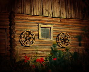 Old wooden wheels on the wooden wall of cowshed