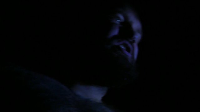 Portrait of emotional swearing man in darkness. Angry aggressive man is having conflict with somebody. Conflict situation. 4K UHD
