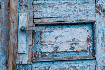 Old door handle close up. Metal handle and door lock of an old wooden blue door.