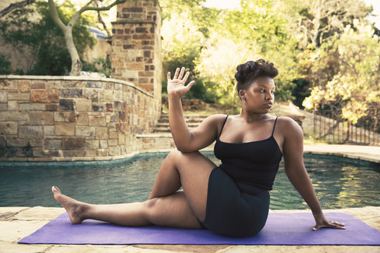 Young woman exercising by swimming pool
