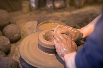 Craftsman artist making craft, pottery, sculptor from fresh wet clay on pottery wheel