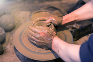 Craftsman artist making craft, pottery, sculptor from fresh wet clay on pottery wheel