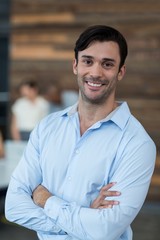 Business executive standing with arms crossed in office