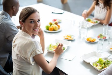 Obraz na płótnie Canvas Smiling business executive having meal in office