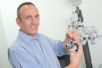 Portrait of optician holding equipment