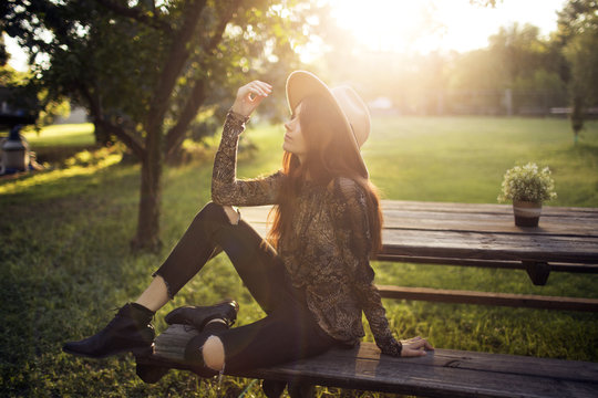 Young woman sitting on bench in park