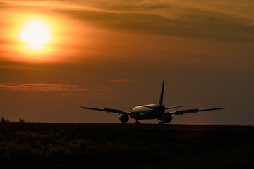 Fototapeta na wymiar Airplane on runway in sunset