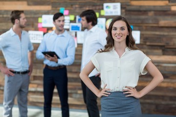 Fototapeta premium Business executive standing with hands on hip in office