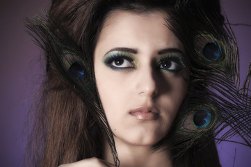 young sensitive brunette woman with peacock feather eyes close