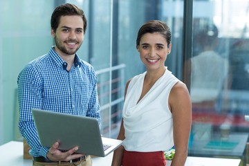 Smiling business executives Standing in office with laptop