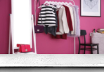 Fashionable clothes hanging on rack at modern dressing room