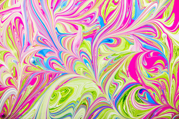 Pink, blue and green color paint mixing together background.