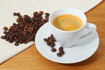 Cup of coffee and coffee beans on the napkin