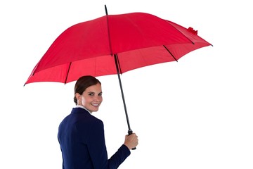 Smiling businesswoman holding red umbrella