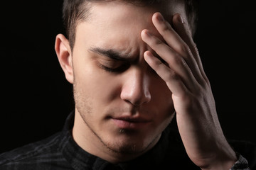 Fototapeta premium Handsome depressed man on black background