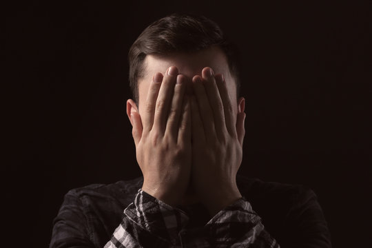 Handsome depressed man on black background