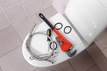 Plumber's tools on toilet at home