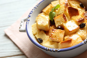 Bowl with delicious bread pudding on napkin